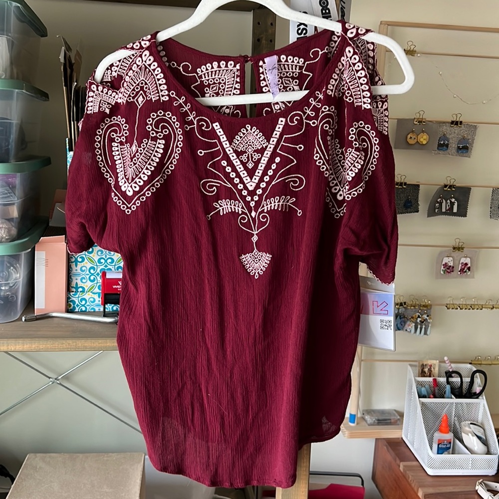 Francesca’s maroon top with cutouts
